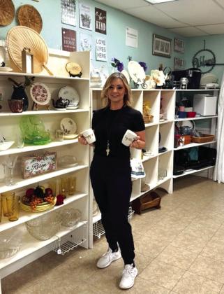 Shared Blessings employee Tabby Carrington is displaying product in the store.