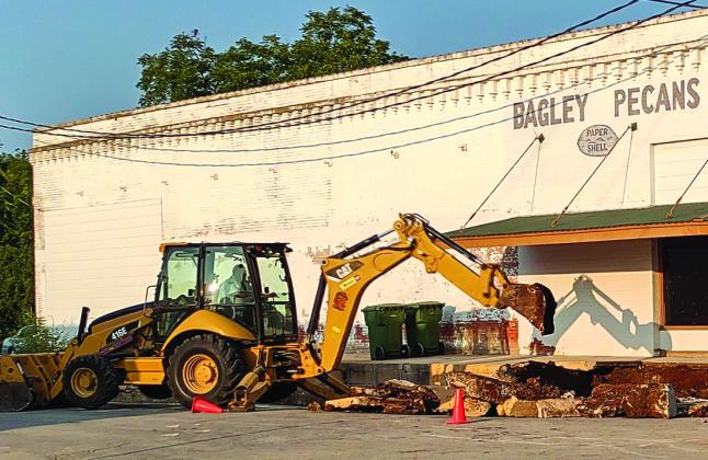 Luis Rios digging up the street with his backhoe