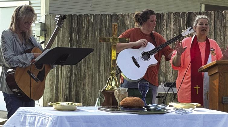Pastor Judy, her daughter Samantha, and Sheria leading worship at Sunday's service in the back yard. Courtesy of Jacqueline Carlson