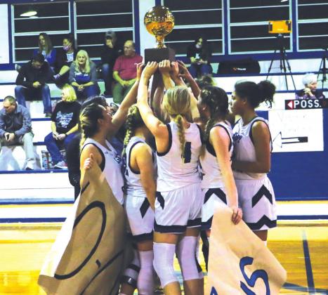 Lady Coyotes hold up their trophy