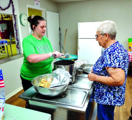 Jordyn Hughes, Cook for the Senior Center, is serving up a delicious, hot meal to Joan Van Gorp at Friday's lunch.