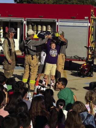 Case Walts is seen here getting suited up for action with help from the SS VFD members. - Courtesy of Kambria King