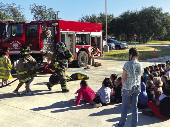 Firefighter Juan Montoya has some help with the fire hose.