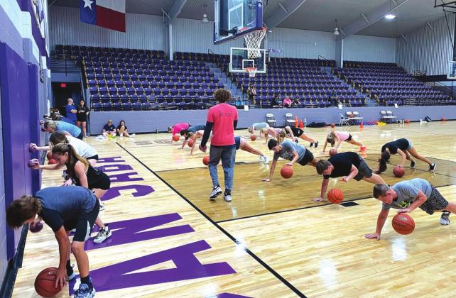 Campers do a drill while dribbling a basketball and balancing a smaller ball with the other hand on Wednesday, June 29, during the Austin Johnson's Academy of Hoops Elite Skills Basketball Camp held at Armadillo Arena in San Saba. (Photo courtesy of Austin Johnson's Academy of Hoops)