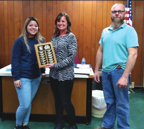 Zane Churchill, Utilities Department Employee, displays an Employee of the Month plaque with her name engraved for selection as the City's Employee of the Month for December. She also received a gift certificate to a local restaurant. On Zane's right is Bridgett Macedo, Utilities Supervisor, and to her left is Michael Nelson, Alderman. (Photo by Djuana Payton)