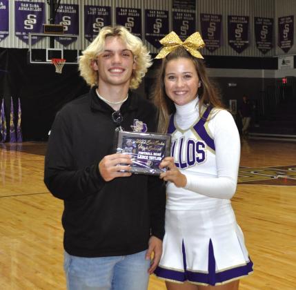 Senior Cheerleader Madison Shahan gives Senior Quarterback Lance Taylor the FOOTBALL BEAU award at the last pep rally.