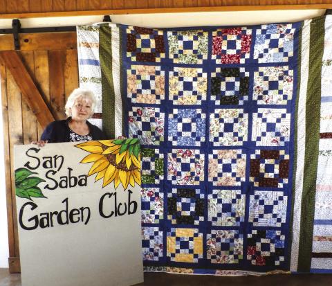 Donna McKinney displaying her hand-made quilt, “Lady Amelia,” which is to be given away at the drawing on Saturday, April 26, at 1:00 p.m.