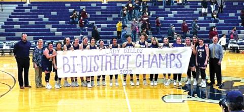 The San Saba High School girls varsity basketball team happily poses with a banner on Monday, February 14th, following the Lady Dillos' dominant 86-36 victory over Charlotte High School in the 2A Bi-District playoffs held at neutral site Champion High School in Boerne. (Photo courtesy of San Saba All-Sports Booster Club)