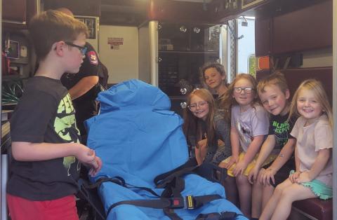 Kids exploring and learning the “inside” scoop of an ambulance at 2024 National Night Out