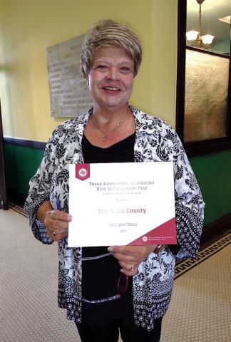 Ms. VanBeck is holding the Zero Lost Time certificate she showed to the Commissioners Court in their meeting on Monday, April 14th. Photo by Djuana Payton