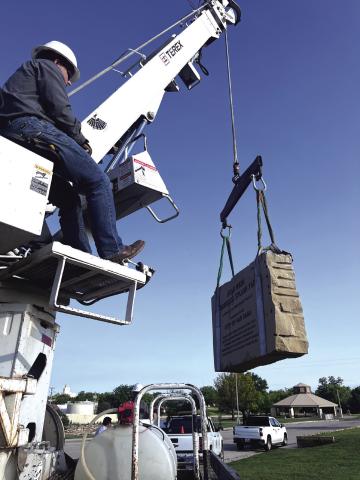 City Employee Jake Uptain lowering the sign into place. Courtesy of Scott Glaze 