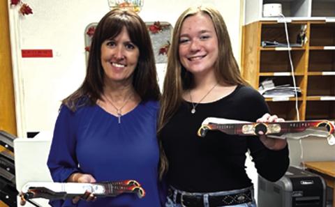 Payton Duggan, Chair to the San Saba County Chamber of Commerce Junior Directors, presents eclipse glasses to Jennifer Bordner, Superintendent of Cherokee ISD.