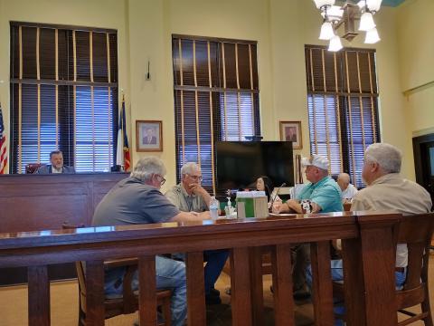 Commissioners Court during the meeting July 20, 2026. From left to right: County Judge Jody Fauley, Mike Poe (Precinct 2), Kenley Kroll (Precinct 3), Christi Whitley (County Clerk), Greg McGregor (Precinct 4), Sheriff Jenkins, James Lebow (Precinct 1).  Photo by Djuana Payton