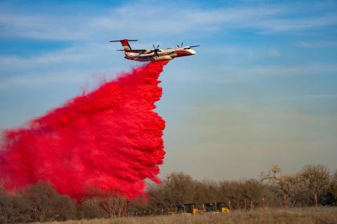 Members of the Texas A&M Forest Service watch as a plane drops fire retardant on a portion of the Smokehouse Creek Fire on Saturday, Mar 02, 2024, in Hemphill County, Texas, after high winds caused a flare-up to reignite the record-breaking fire. (Sam Craft/Texas A&amp;M AgriLife Marketing and Communications)