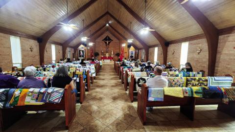 Fr. Joe blesses the quilts, some of the recipients, and volunteers at St Mary’s Catholic Church.