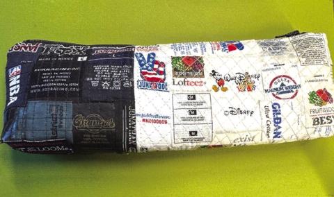 A zipper pouch made from “created fabric” made by sewing T-shirt labels onto a base. The woman who made this has a Tshirt quilt business and finds creative ways to use what would otherwise end up in the trash.