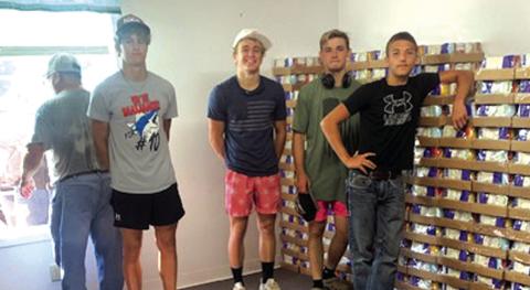 Convoy of Hope - (L-R) Franky Soto (at window), Layne Ward, Evan Deeds, Christian McKinnerney, and Trendon Vogel volunteered after football practice to unload pallets of canned goods. Photo by Sue Ransom
