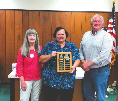 Kim Wilson, Accounts Payable Clerk, displays an Employee of the Month plaque with her name engraved for selection as the City's Employee of the Month for July. She also received a gift certificate to a local restaurant. At Kim's right is Charlene Lindsay, Supervisor - City Treasurer, and on her left is Shawn Oliver, Alderman, taking part in the formal presentation.