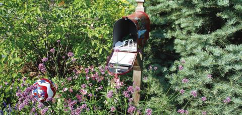 A mailbox filled with garden tools and set in the garden for convenient access. Courtesy of www.MelindaMyers.com