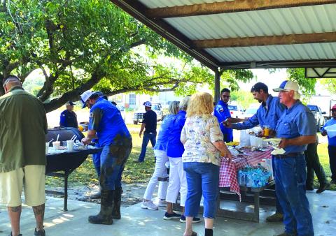 Table with the breakfast items and staff serving the goodies.