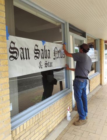 Devin Cordoza is seen here installing the Perforated Vinyl sign on our front window this week. Photo by Carolyn Boswell-Preece