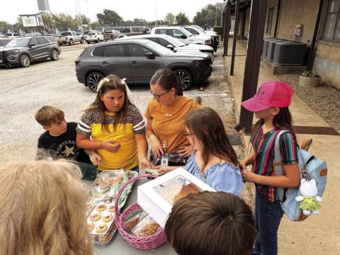 Jaxon Owen and Phoebe Valdez helping customers at the bake sale. Courtesy of Shannon Padgett