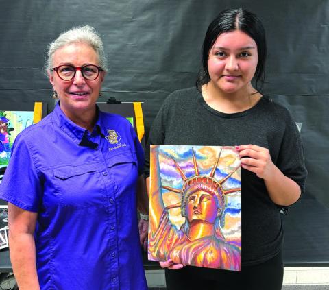 Judy is holding her awarding winning art piece and is pictured with Shara Wright. Courtesy of August Pfluger