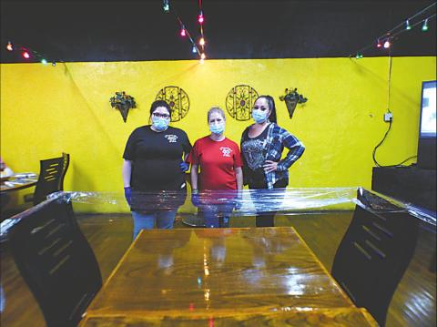 Happy to pose with their masks and gloves are servers for the day (L-R) Tonya Marie Acuna and Jennifer Blocker. Next to Jennifer is Shelby Cisneroz who wears her mask while filling in as hostess and cashier that day. These pretty ladies are switching out roles to help things flow smoothly at Pepperbelly’s. Notice the plastic wrap around the chairs to prevent customers from seating and to stay within the 25% occupancy limit guideline. Photo by Donna Webb