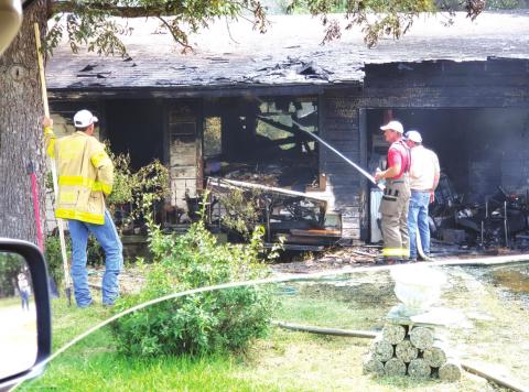 Shown are staff from the San Saba Volunteer Fire Department (VFD) fighting to ensure the raging structure fire in the 500 block of Lewis Street. The fire which occurred Thursday, July 1st, completely destroyed the home and its contents. The occupant escaped with a major burn on her neck area. (Photo by Joanie Hunt)