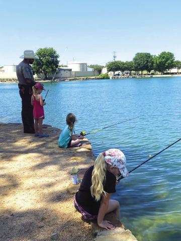 Kids fishing with Game Warden Ray Milloway at Mill Pond Park during Kids’ Nature Kamp 2023. See back page for story and more pictures.