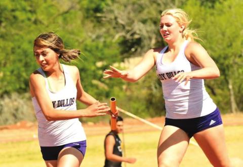 San Saba High School girls varsity track and field athlete Leslie Aguirre (left) takes the baton from Lady Dillos teammate Lexy Amthor (right) on Friday, April 8th, during the girls’ 4x100- meter relay event at the District 29-2A meet hosted by Mason High School. (Photo by Rita Boultinghouse)