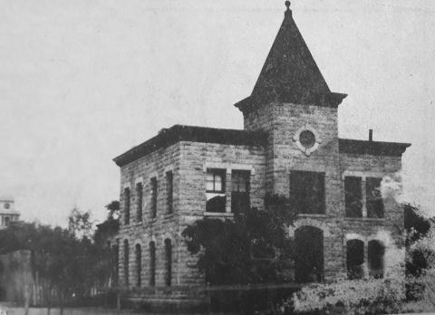 1924-25 –– The San Saba County Jail looked like this about 65 years ago, complete with the peaked roof which is now no longer there. The upper window with the curtain blowing out of it, is now barred and the high wood fence has been replaced with a chain-link fence. Oll Hart was said to be the jailer. The picture was provided by Mrs. Elmer House. Taken from the June 29, 1989 issue of the San Saba News &amp; Star.