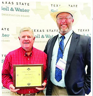 John Frantz (left) shows the plaque he received for 50 years’ service as District Director of Hartley Soil and Water Conservation District. Next to him is Rick Johnson,State Field Representative for the Texas Soil and Water Conservation Board.