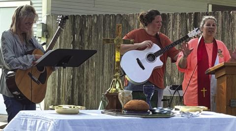 Pastor Judy, her daughter Samantha, and Sheria leading worship at Sunday's service in the back yard. Courtesy of Jacqueline Carlson