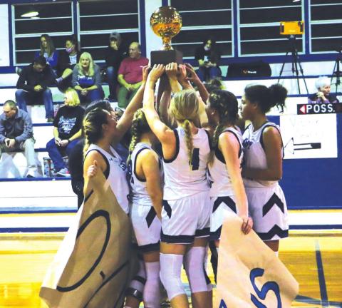 Lady Coyotes hold up their trophy