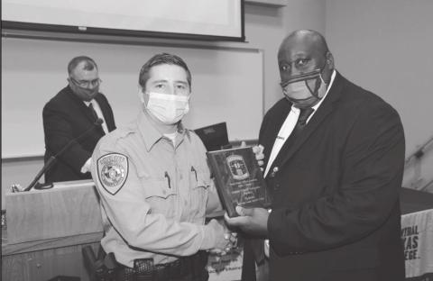 Ty Mann of the San Saba County Sheriff’s Department accepts the Top Gun award for firearms proficiency from instructor Johnnie Thomas during the Central Texas College Police Academy graduation ceremony last week.