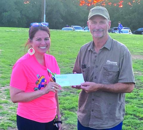 Jack Blossman is accepting a $1,000 donation check to the San Saba Volunteer Fire Department from CTTC presented by Ana Sanderson.