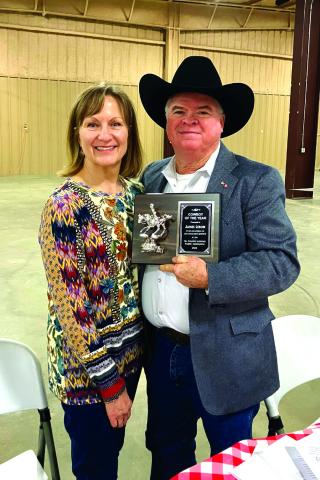 James Lebow proudly holding his award with his wife Lois at his side.